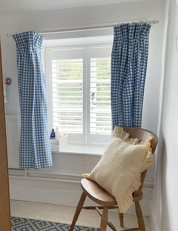 window with blue curtains and a white full height shutter